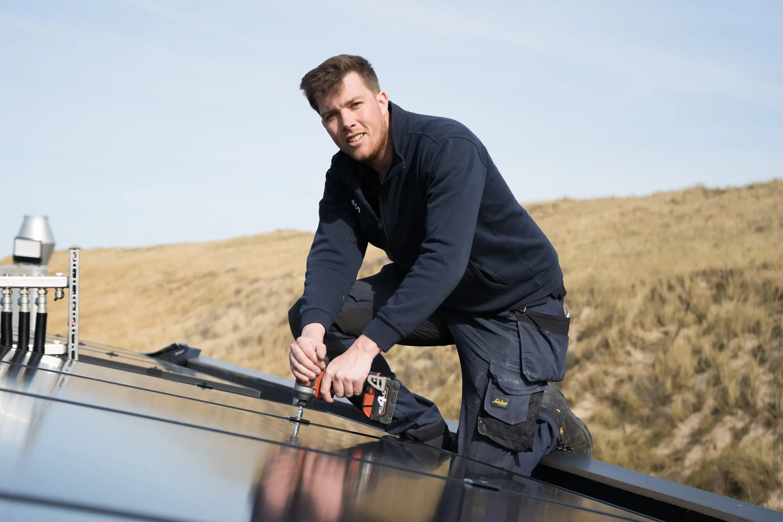 Monteur installeert PVT-panelen op een dak