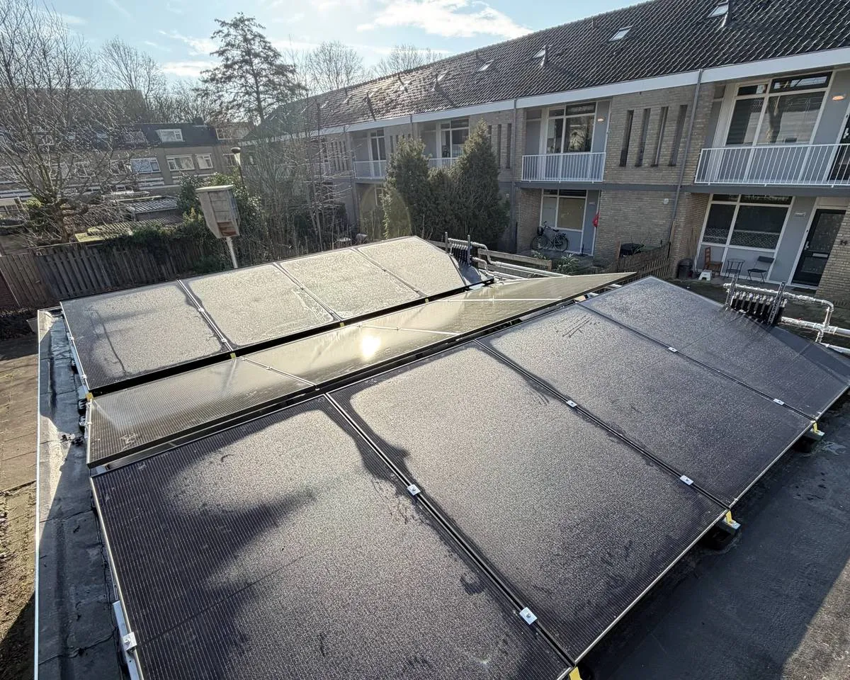 PVT-panelen op het platte dak van een bijgebouw aan de Reyerslaan in Nieuwegein, met de corporatiewoningen van Woonin op de achtergrond